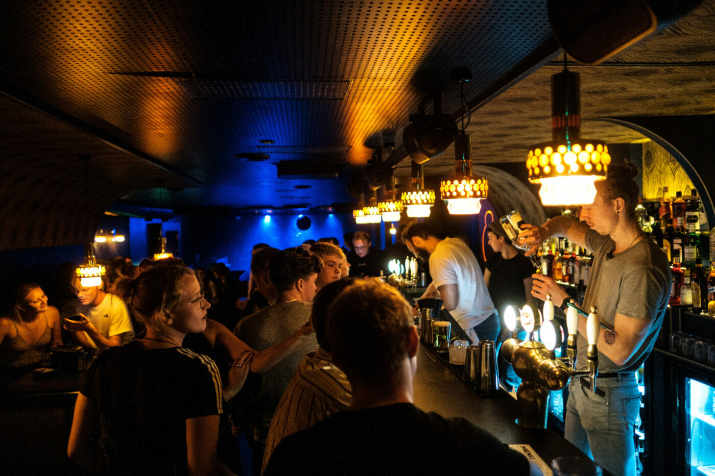 Travl bar med dæmpet belysning og mange kunder.